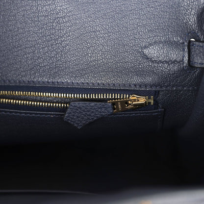 Hermes Birkin 25 handbag with dark blue leather zipper pocket and gold zipper pull.