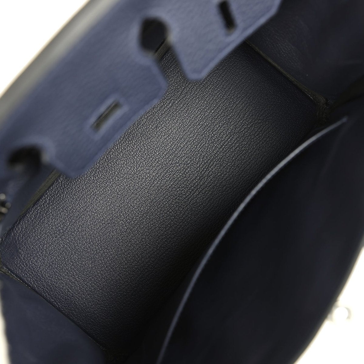 Birkin 25 handbag close-up of dark blue pebbled leather side panel and stitching