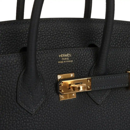 Black leather Birkin-style handbag with gold turn-lock and top handle tabs