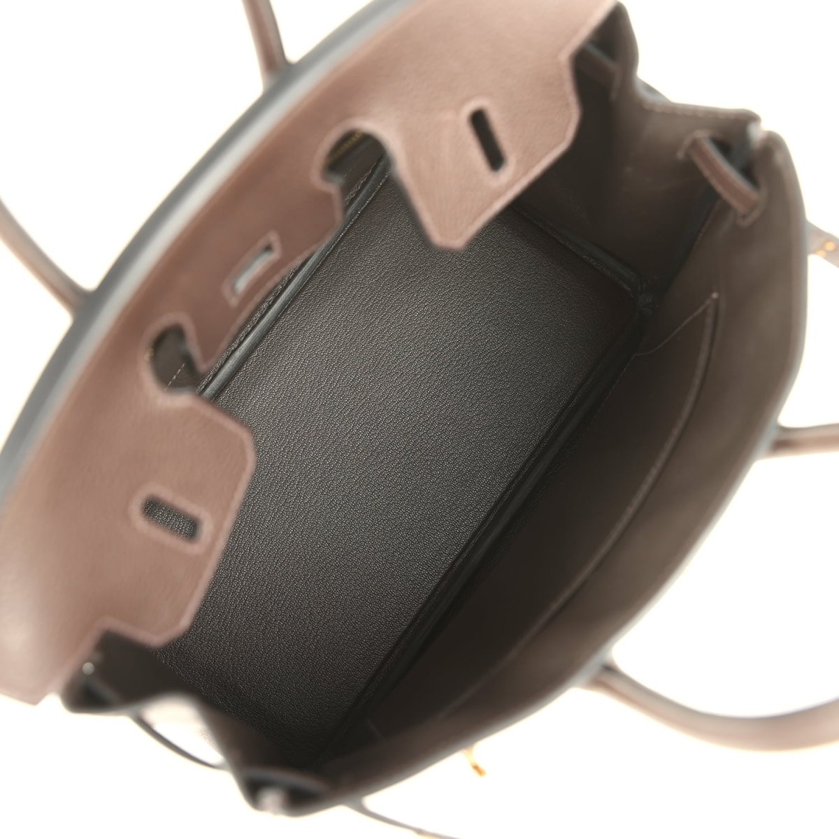 Brown leather handbag interior view with open lining and pocket