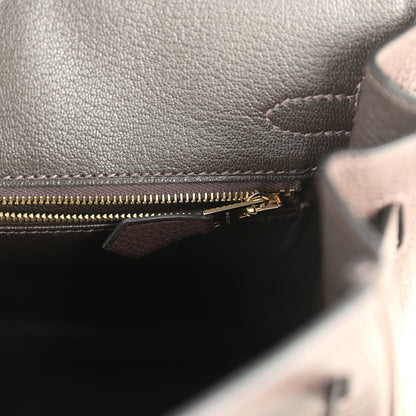Brown leather bag interior zipper with gold-tone pull and stitching