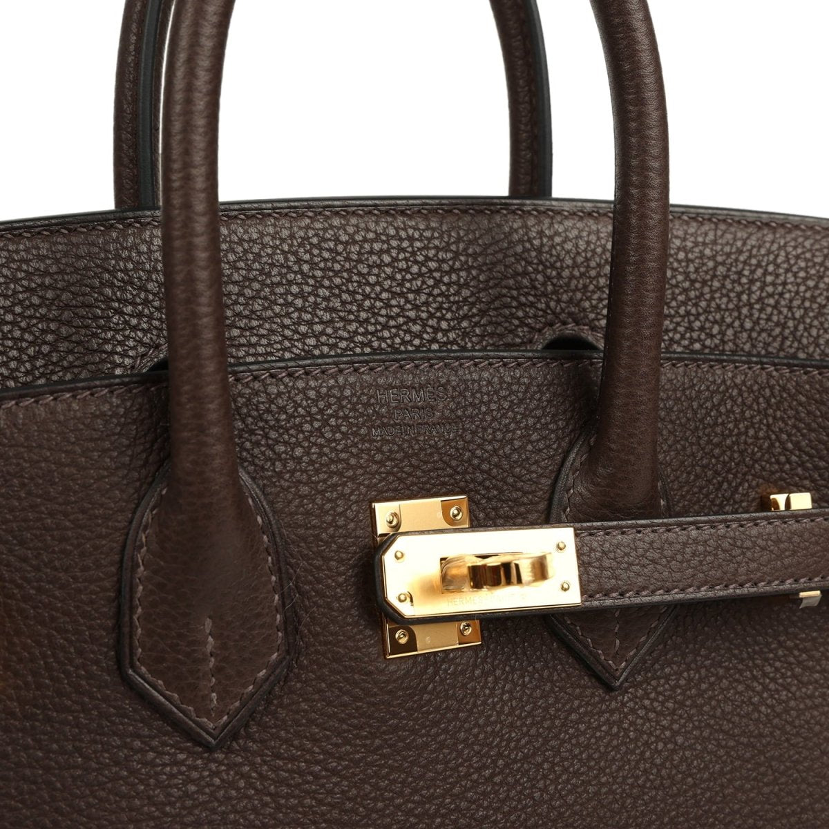 Brown leather handbag strap detail with gold-tone clasp and stitching