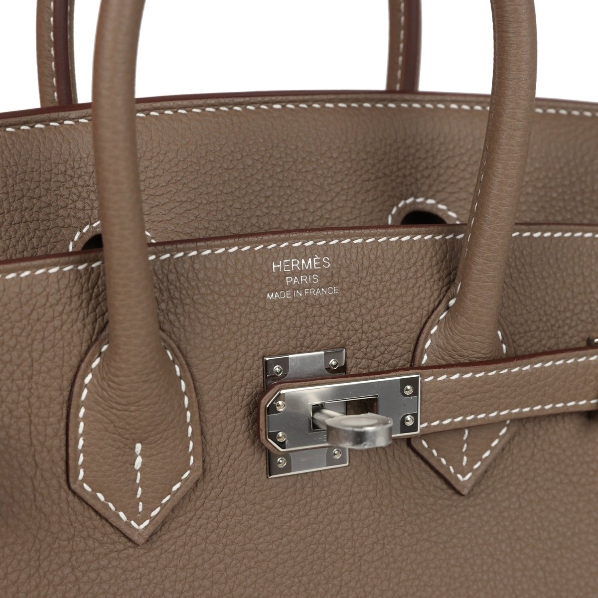 Hermes Birkin 25 handbag close-up of taupe leather, front clasp, and stitched handle trim