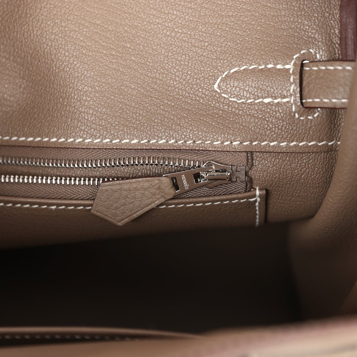 Hermes Birkin 25 handbag interior close-up with zip track, silver-tone zipper pull, and tab