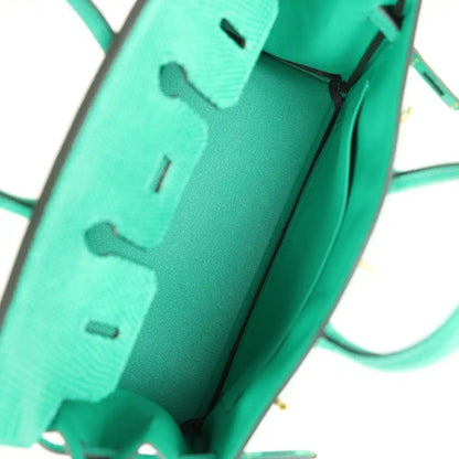 Mint green lizard handbag interior with partial stamp and side strap