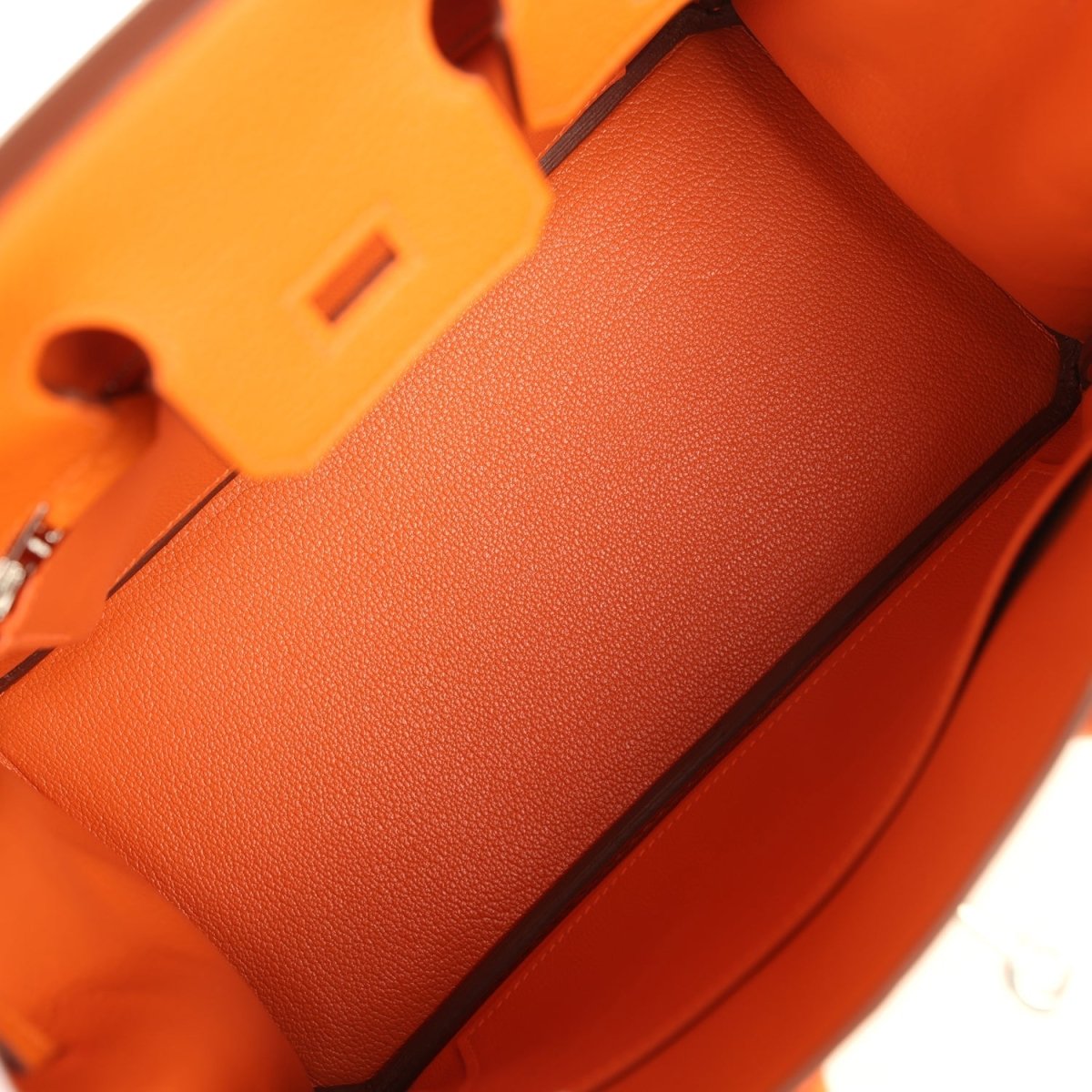 Orange leather Birkin 25 handbag interior pocket area with structured lining and corner edge