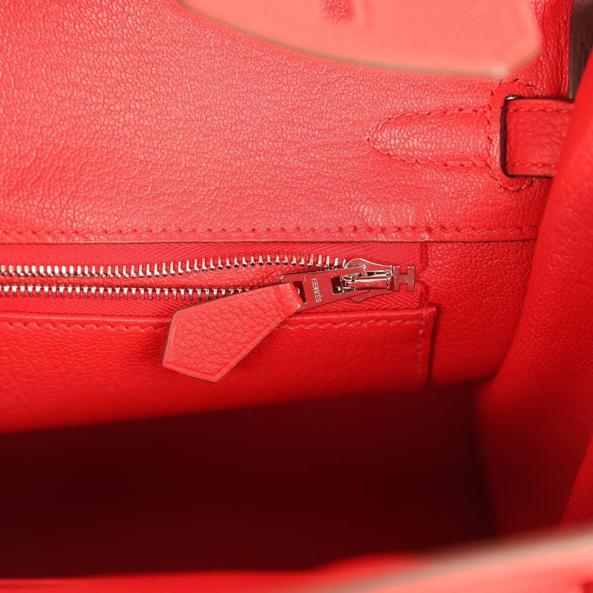 Hermes Birkin 25 handbag close-up of red leather zipper and pull, palladium hardware