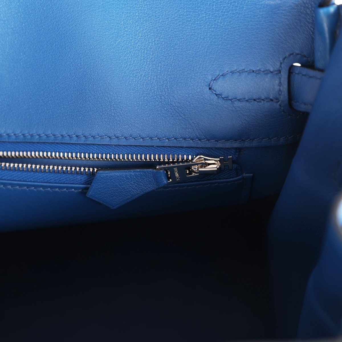 Blue leather zipper pocket with metal teeth and small tab pull