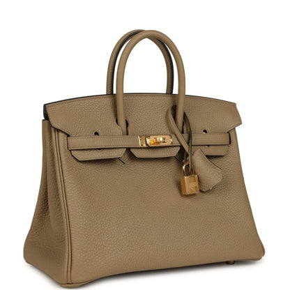 Beige pebbled leather handbag with top handles, gold hardware, and turn-lock