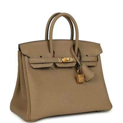 Beige pebbled leather handbag with top handles, gold hardware, and turn-lock