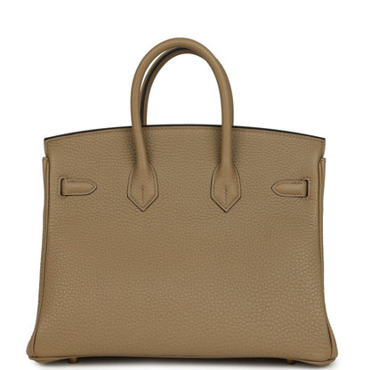 Beige pebbled leather handbag back view with decorative panels and top handles