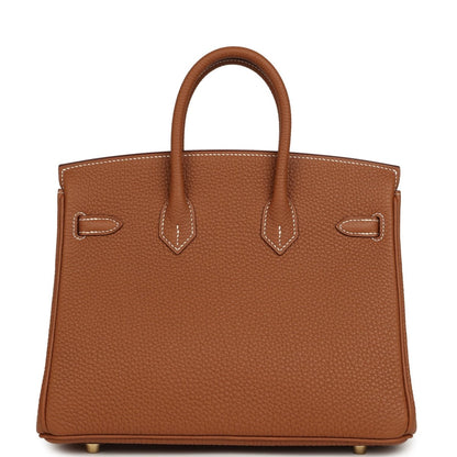 Tan leather handbag with stitched handles and front buckle accents with gold-tone hardware.