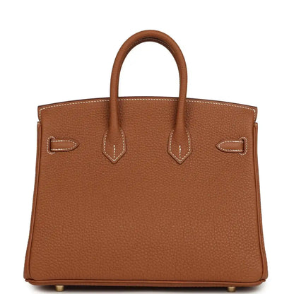 Tan leather handbag with stitched handles and front buckle accents with gold-tone hardware.