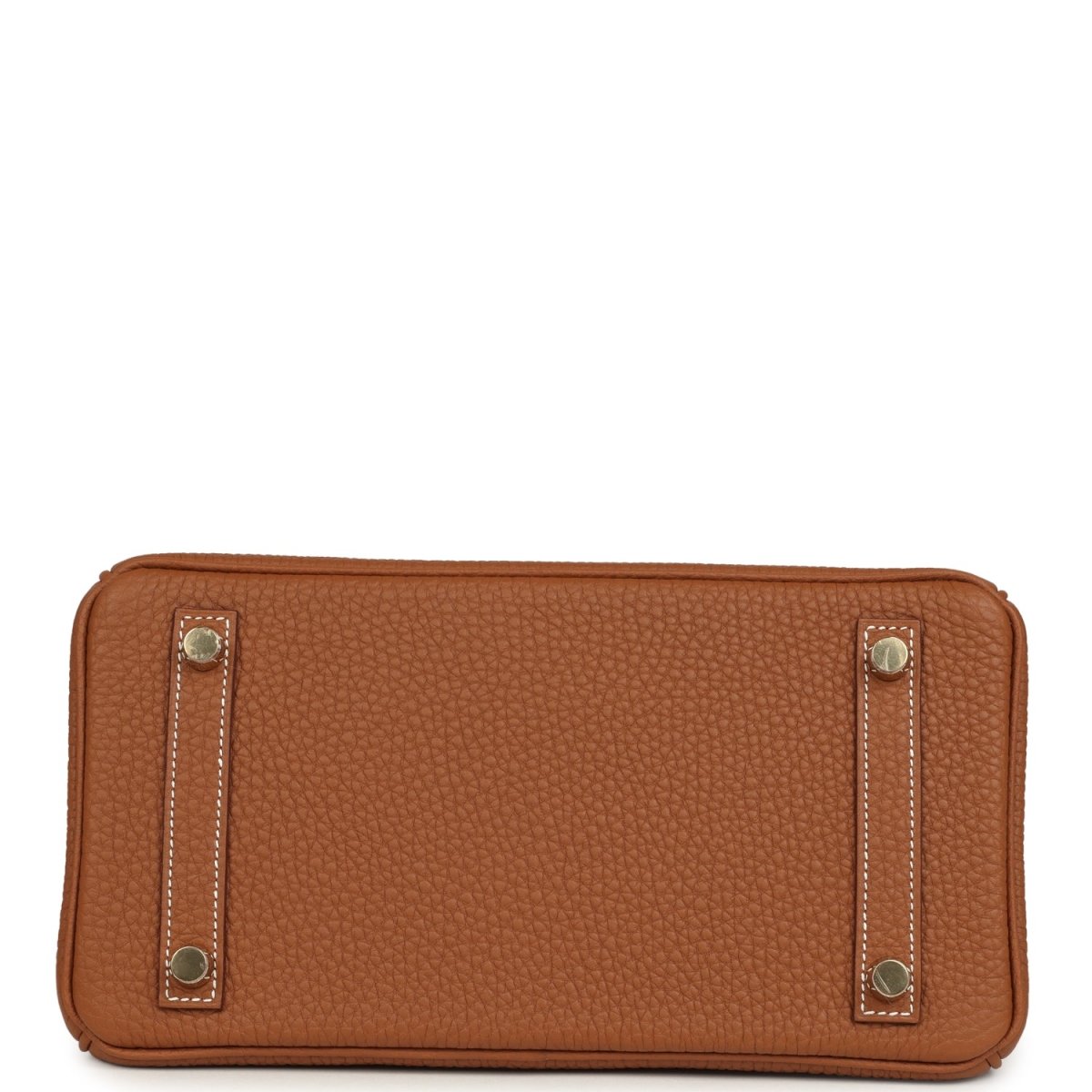 Tan leather handbag base view with gold-tone corner feet and rectangular side pocket tabs.