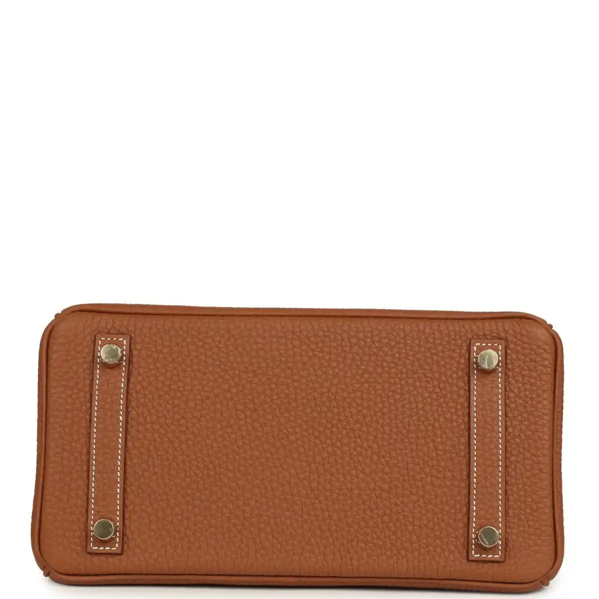 Tan leather handbag base view with gold-tone corner feet and rectangular side pocket tabs.