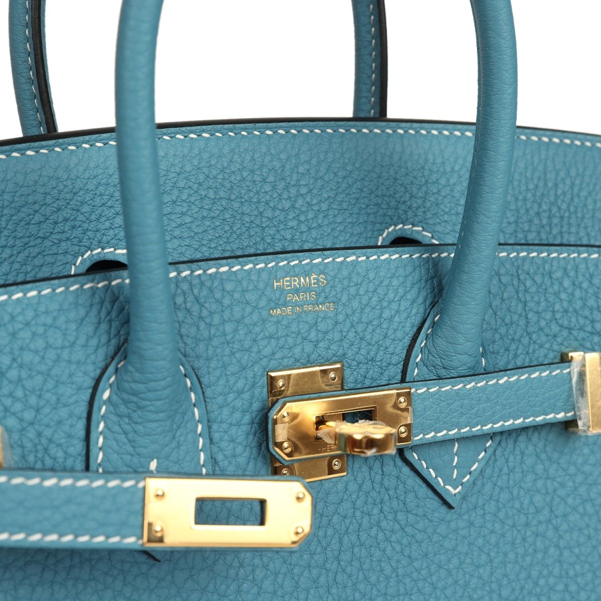 Teal-blue Togo leather handbag interior, showing logo stamp and gold-toned clasp hardware