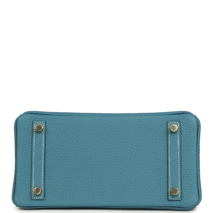 Teal-blue leather crossbody-style flap pouch with gold-tone corner hardware and stitching