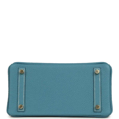 Teal-blue leather crossbody-style flap pouch with gold-tone corner hardware and stitching
