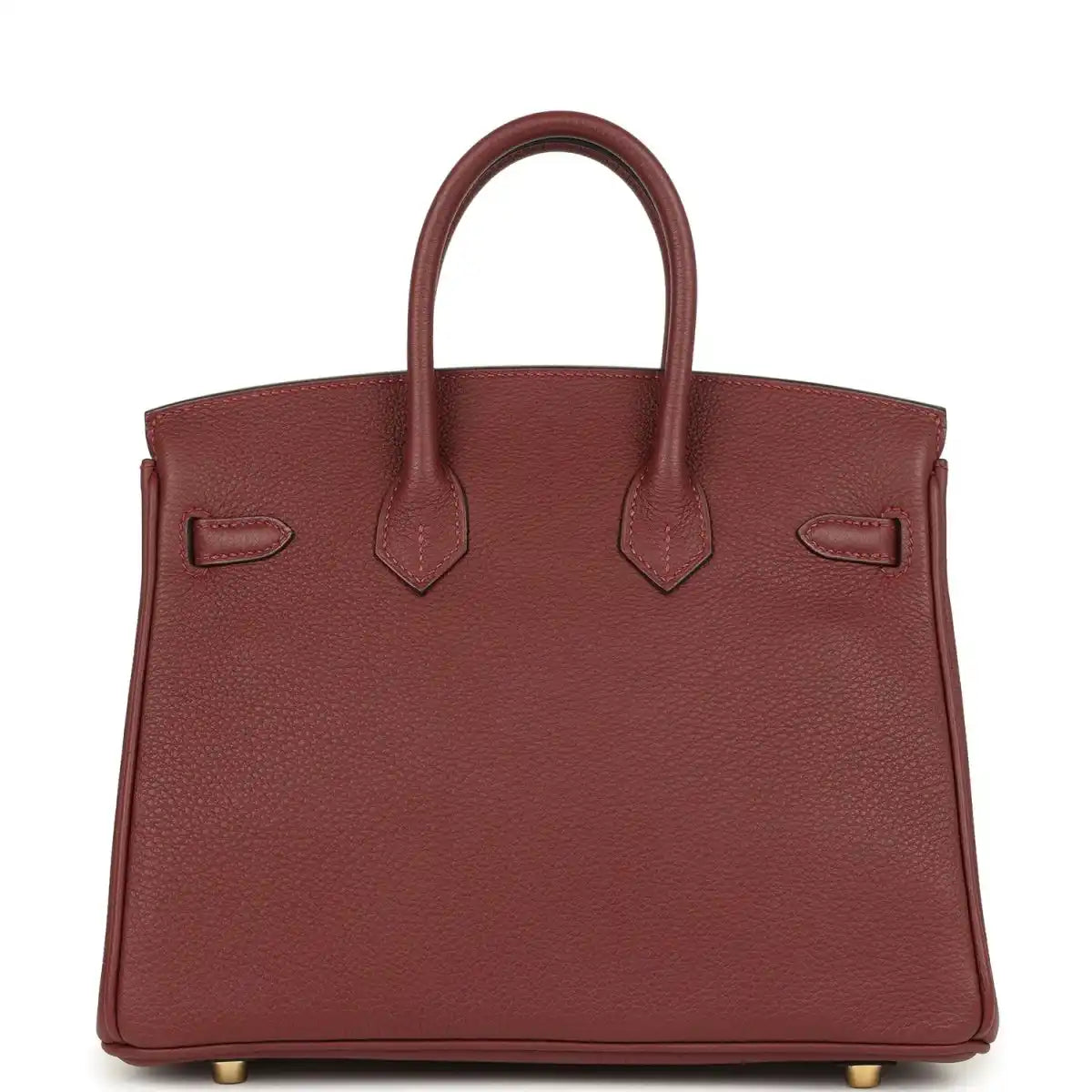 Burgundy leather handbag back panel with hanging straps and gold feet.