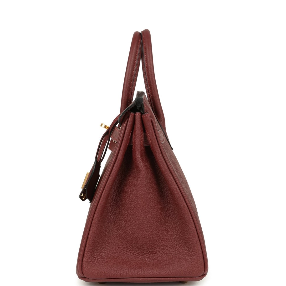 Burgundy leather handbag side view with handles and hanging lock detail.
