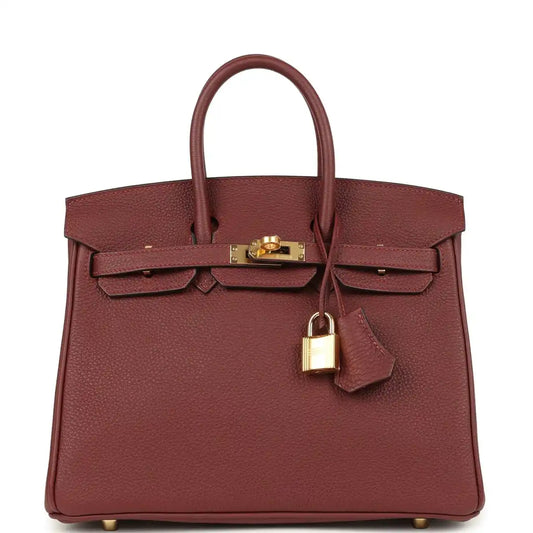Burgundy leather top-handle handbag with gold hardware, front flap and turn-lock.