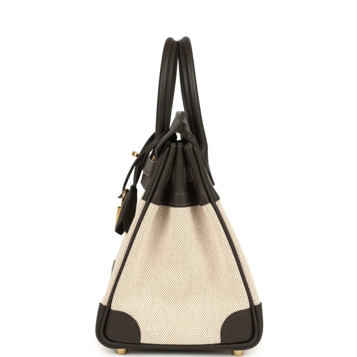 Small two-tone handbag with dark leather handles, beige canvas body and gold-tone lock charm