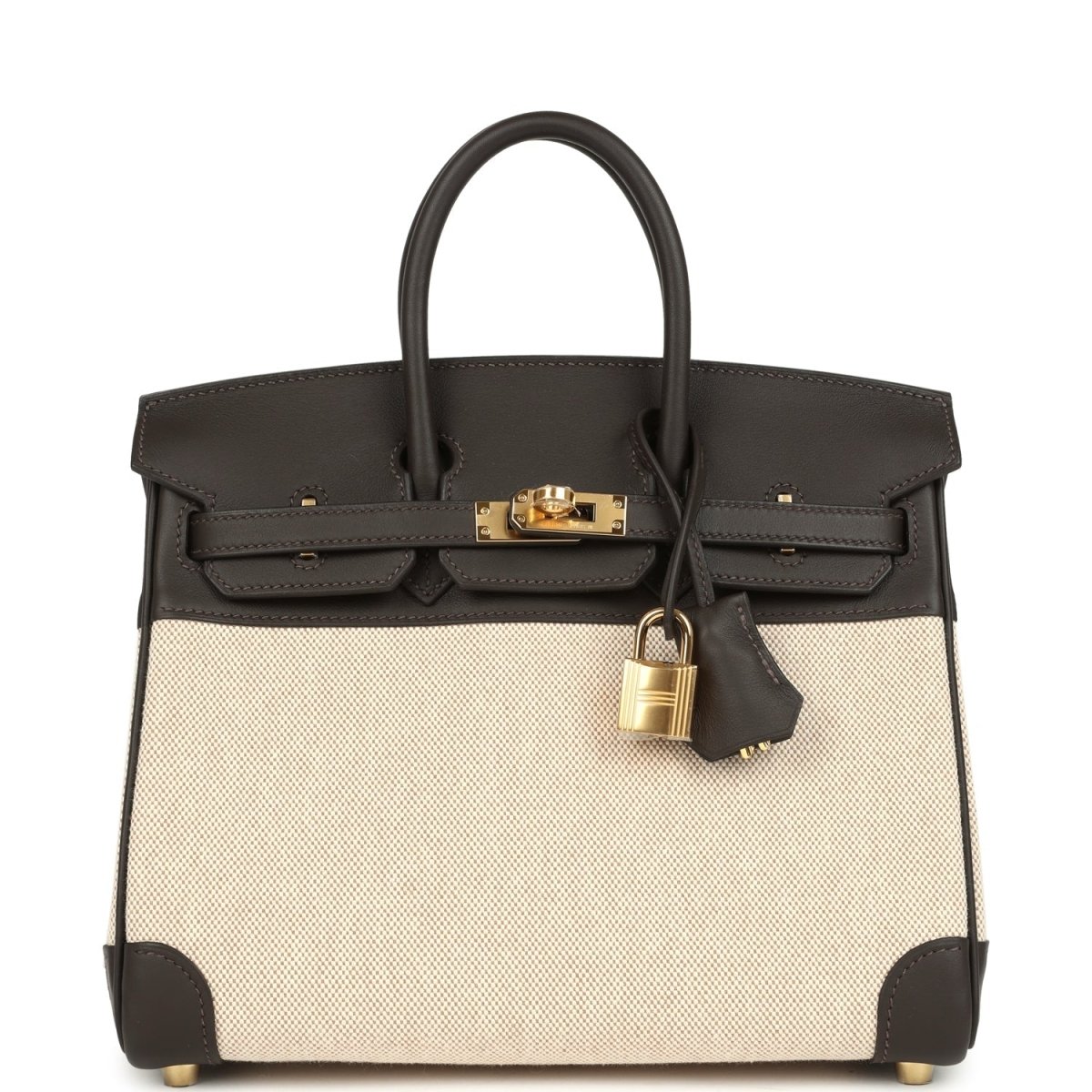 Two-tone handbag with dark leather top handles, beige canvas body, gold-tone lock and front flap