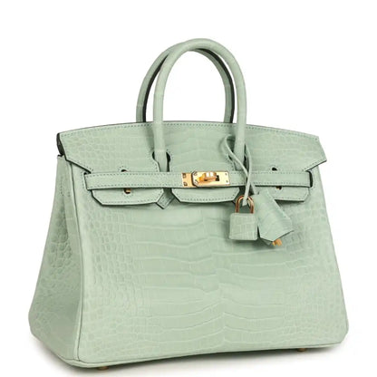 Light green croc-embossed handbag with front flap, gold turn-lock, and hanging key charm