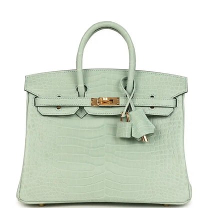 Light green croc-embossed handbag with twin top handles, front flap, and gold clasp