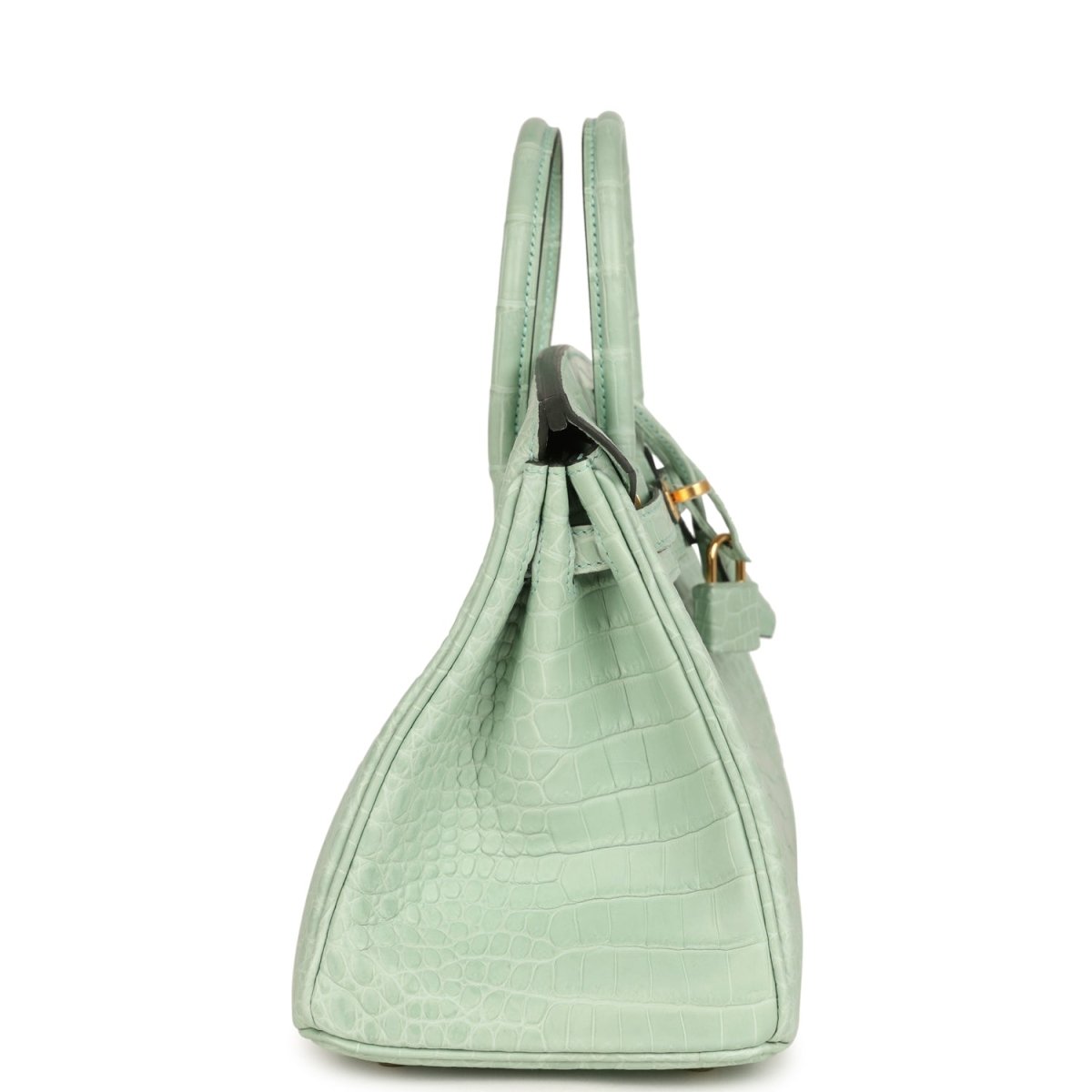 Light green croc-embossed handbag with twin handles, side profile, and front turn-lock