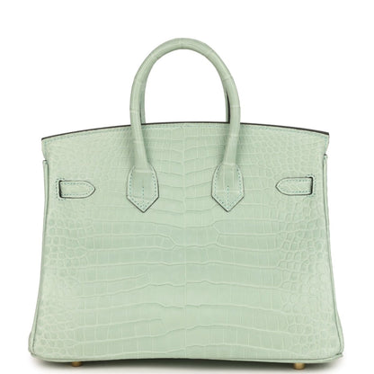 Light green croc-embossed handbag with twin handles and flap front, decorative strap detail