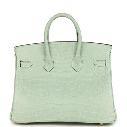 Light green croc-embossed handbag with twin handles and flap front, decorative strap detail
