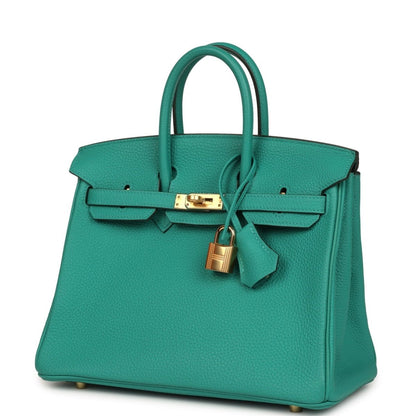 Green leather handbag with top handles, front strap clasp and gold lock charm