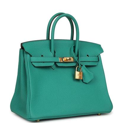 Green leather top-handle handbag with front strap, gold lock and hanging charm