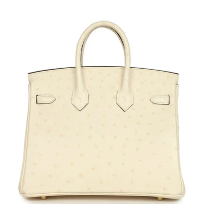 Nata ostrich handbag front panel with two pockets and top handles, gold-tone hardware.