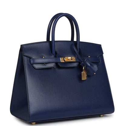 Structured blue handbag with top handles, front flap, gold hardware and hanging lock charm