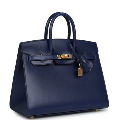 Structured blue handbag with top handles, front flap, gold hardware and hanging lock charm
