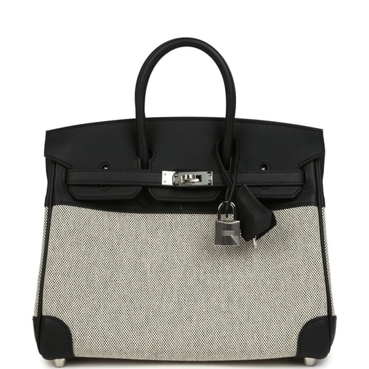 Black and cream canvas Hermes Birkin 25 handbag with top handles and front clasp.
