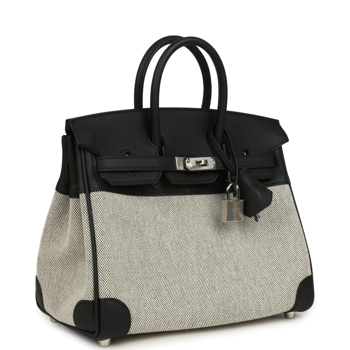 Black and cream canvas Hermes Birkin 25 handbag with top handles and front clasp.