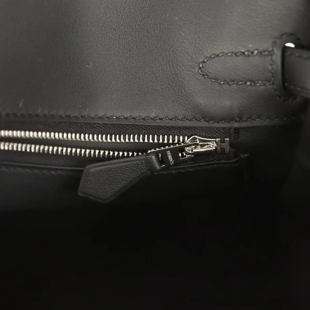 Black leather Hermes Birkin 25 interior pocket with zipper and leather tab pull.