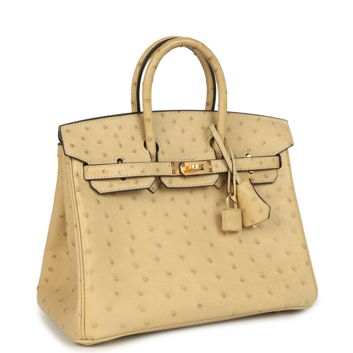 Tan ostrich leather handbag with top handle and front belt-style flap with gold hardware.