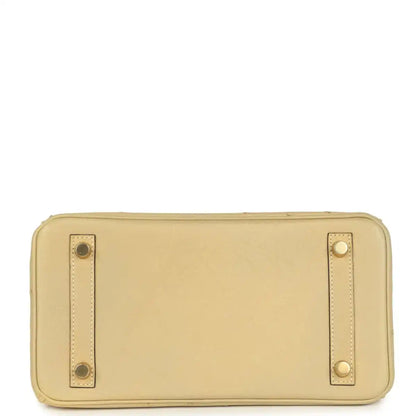 Tan ostrich leather clutch-style pouch with exterior snap details and gold-tone hardware.
