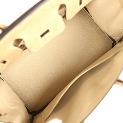 Tan interior view of ostrich leather handbag showing lining pocket and smooth leather panel.