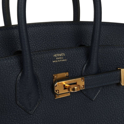 Gold front clasp detail on blue Togo leather Birkin handbag with embossed interior markings