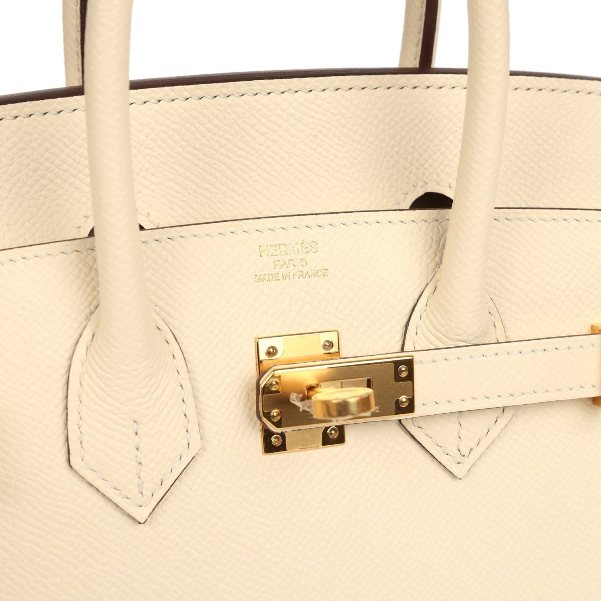 Hermes Birkin Sellier 25 handbag close-up of gold lock plate and cream leather stitching
