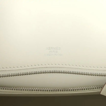 Hermes Paris logo embossed on cream lining above zipper track in leather handbag.