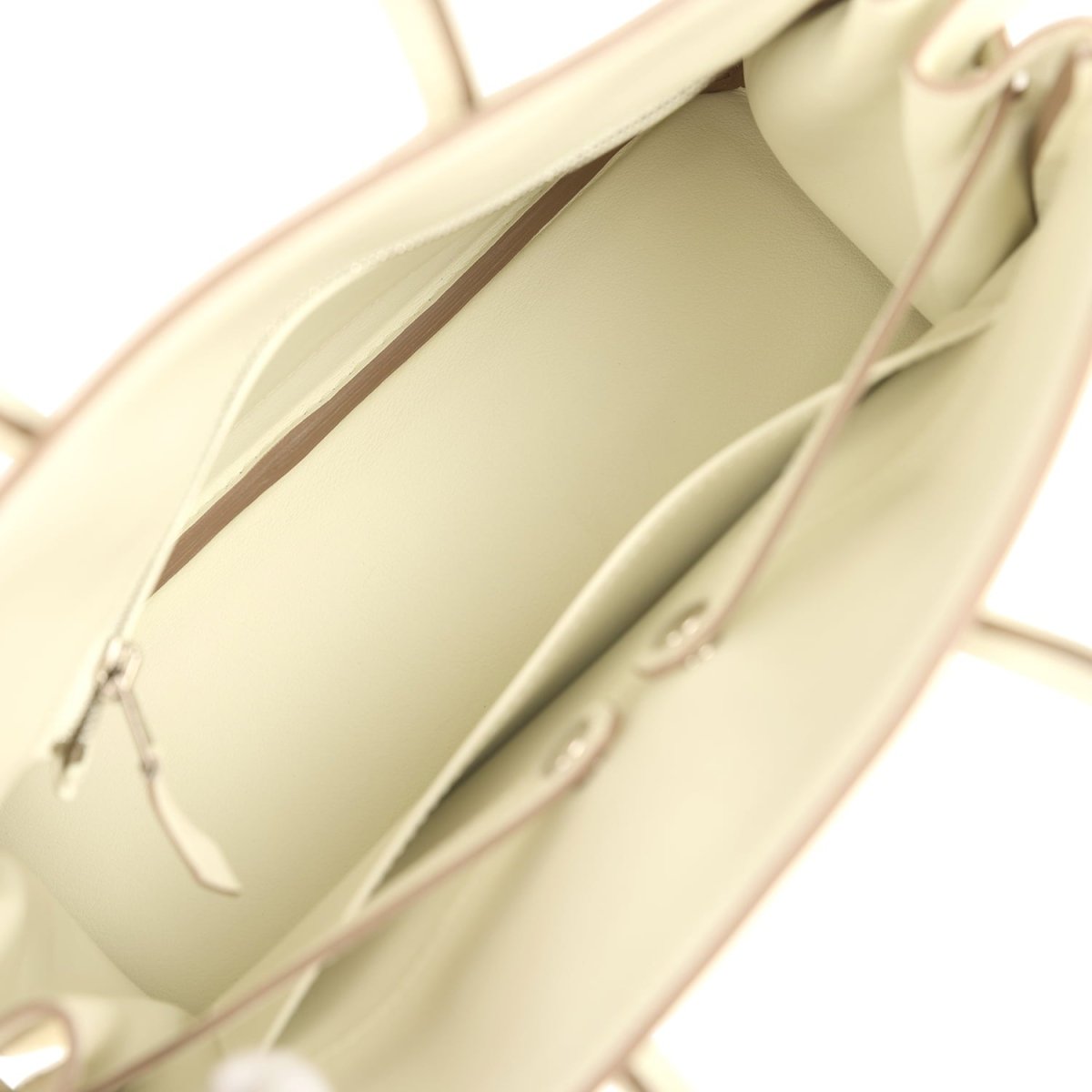 Cream leather handbag interior with stitched lining and small zip pocket.