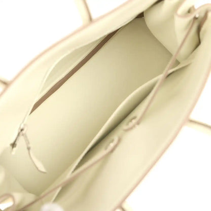 Cream leather handbag interior with stitched lining and small zip pocket.