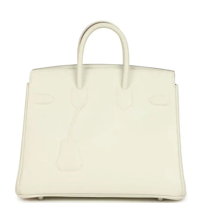 Cream leather handbag with embossed motifs and two top handles, front view.