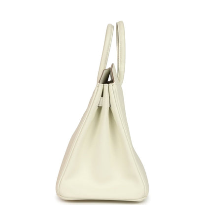 Cream leather handbag with open top showing stitched interior and short handles.